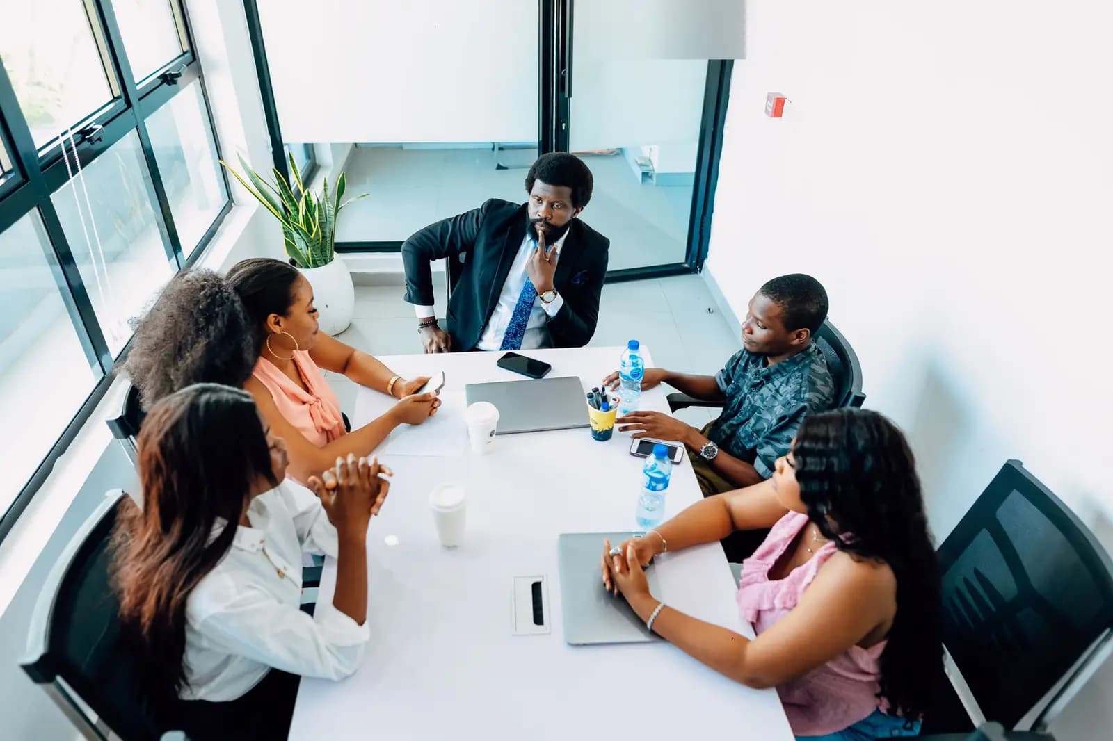 Une équipe de direction en réunion autour d'une table, dans un bureau lumineux